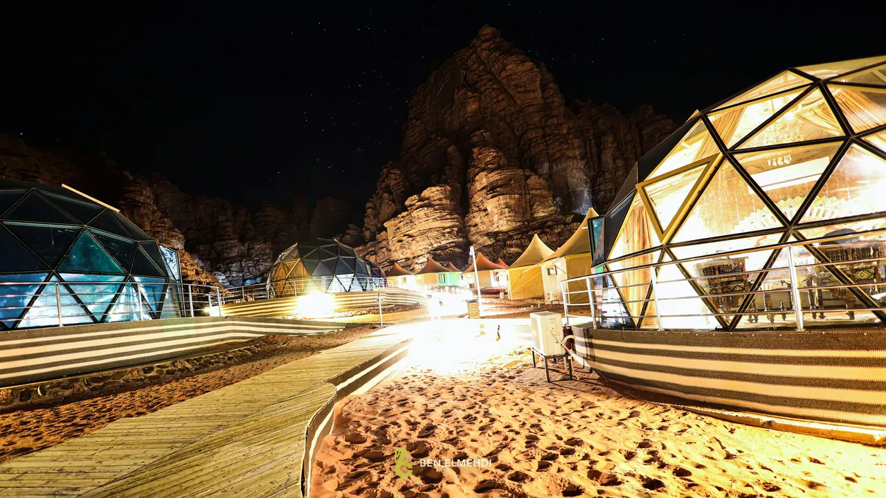Dômes géodésiques illuminés la nuit, dans un camp au désert