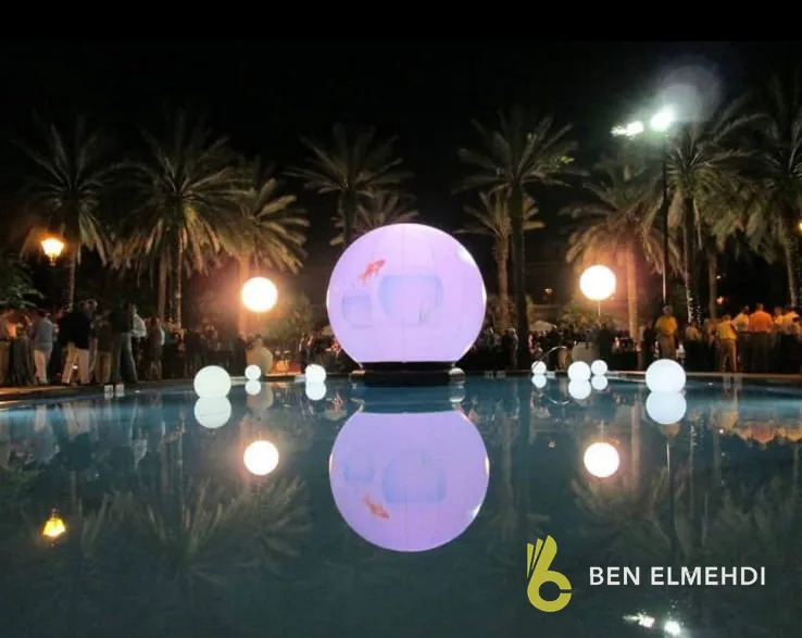 Sphères lumineuses flottantes sur une piscine, la nuit